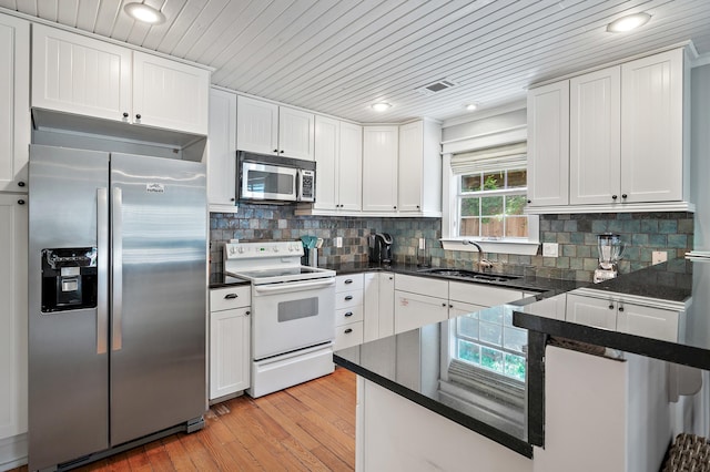 kitchen featuring white cabinets, appliances with stainless steel finishes, light wood-type flooring, and sink