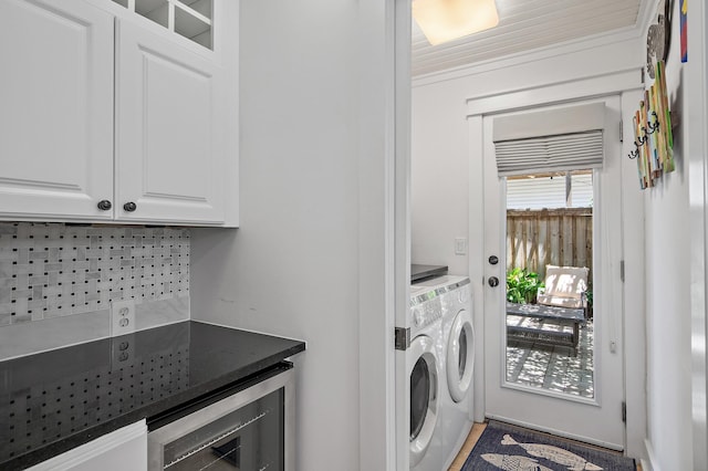 washroom with washer and dryer, wine cooler, and cabinets