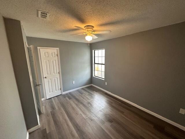 spare room with ceiling fan, a textured ceiling, and wood-type flooring