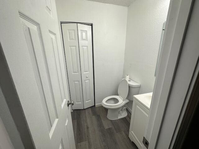 bathroom with wood-type flooring, vanity, and toilet