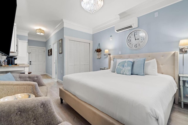 bedroom with ornamental molding, a wall mounted air conditioner, an inviting chandelier, and light hardwood / wood-style flooring