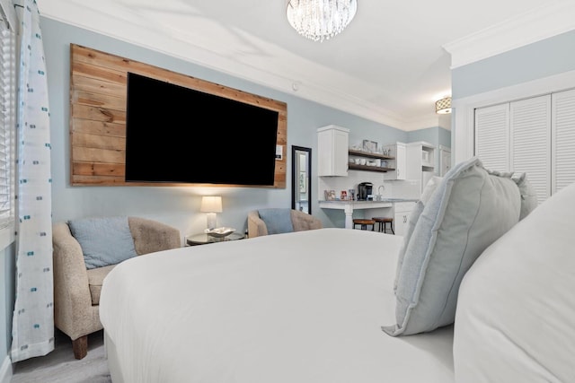 bedroom featuring ornamental molding, a closet, and an inviting chandelier