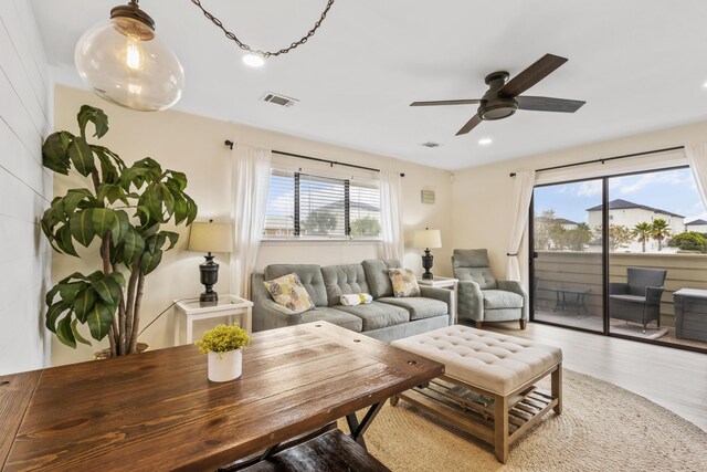 living room with a wealth of natural light, ceiling fan, and light hardwood / wood-style floors