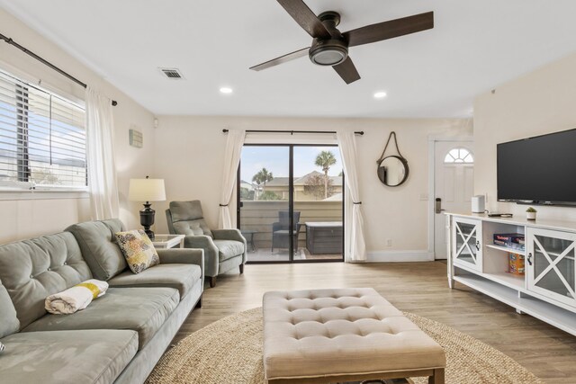 living room with light wood-type flooring and ceiling fan