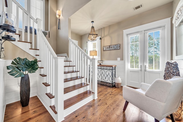 staircase with a chandelier and wood-type flooring