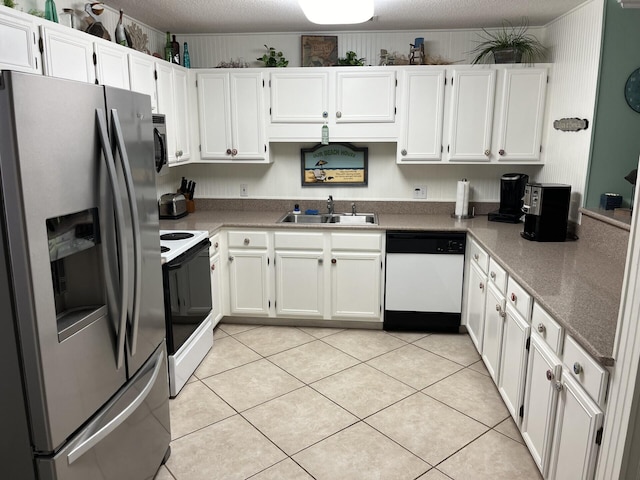 kitchen with sink, light tile patterned floors, a textured ceiling, white cabinetry, and stainless steel appliances