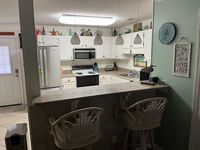 kitchen featuring sink, kitchen peninsula, a breakfast bar area, white cabinets, and appliances with stainless steel finishes