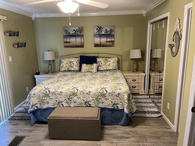 bedroom featuring ceiling fan, crown molding, a textured ceiling, a closet, and hardwood / wood-style flooring