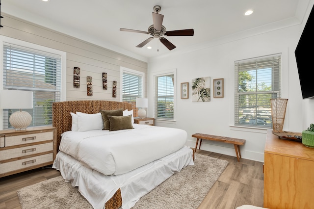 bedroom with ceiling fan, light hardwood / wood-style floors, and crown molding