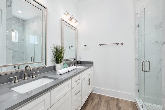 bathroom featuring hardwood / wood-style flooring, vanity, and walk in shower