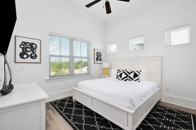 bedroom featuring hardwood / wood-style flooring, ceiling fan, and crown molding