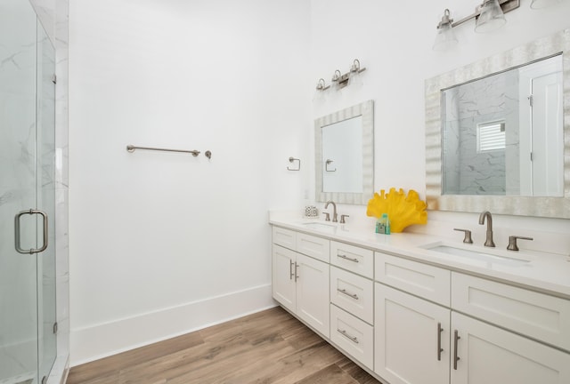 bathroom with wood-type flooring, vanity, and a shower with door