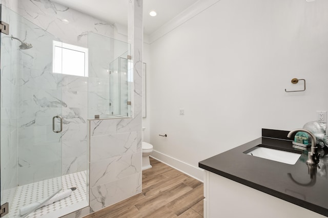 bathroom with walk in shower, crown molding, toilet, vanity, and hardwood / wood-style flooring