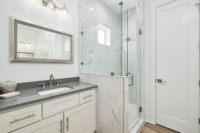 bathroom featuring vanity, wood-type flooring, and walk in shower