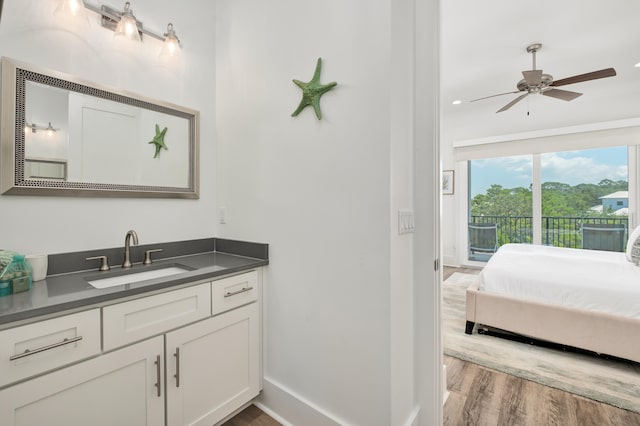 bathroom with hardwood / wood-style floors, ceiling fan, and vanity