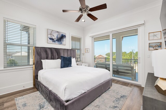 bedroom featuring multiple windows, dark hardwood / wood-style flooring, access to outside, and ceiling fan