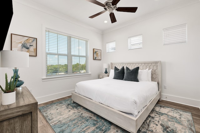 bedroom featuring ceiling fan, dark hardwood / wood-style floors, and crown molding