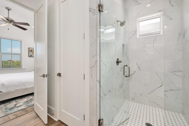 bathroom featuring ceiling fan, a shower with door, and hardwood / wood-style flooring