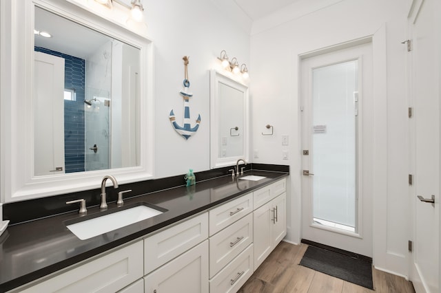 bathroom with vanity, ornamental molding, an enclosed shower, and hardwood / wood-style flooring