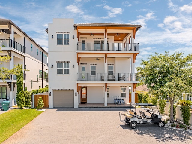 view of front of house with ceiling fan and a balcony