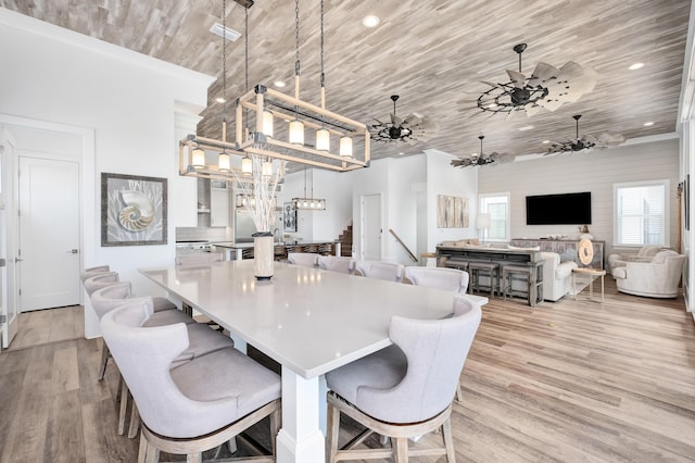 dining space featuring light hardwood / wood-style flooring, ceiling fan, and wood ceiling