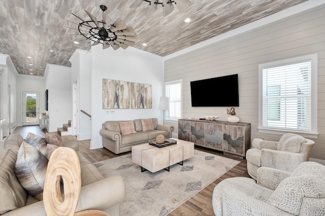 living room featuring a healthy amount of sunlight, wooden walls, and wood-type flooring