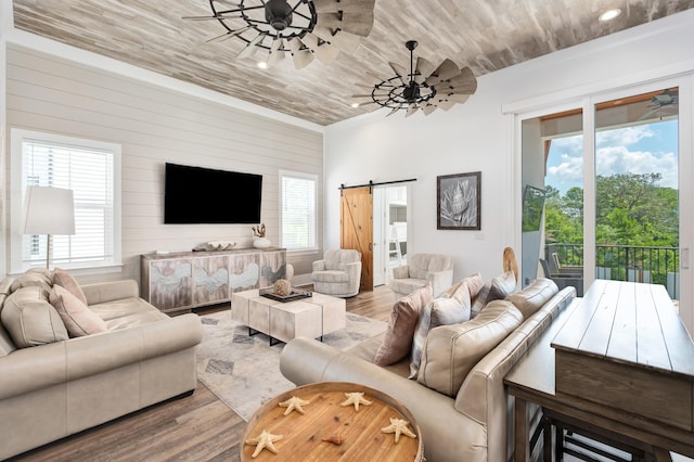 living room with a barn door, light hardwood / wood-style floors, plenty of natural light, and wood ceiling