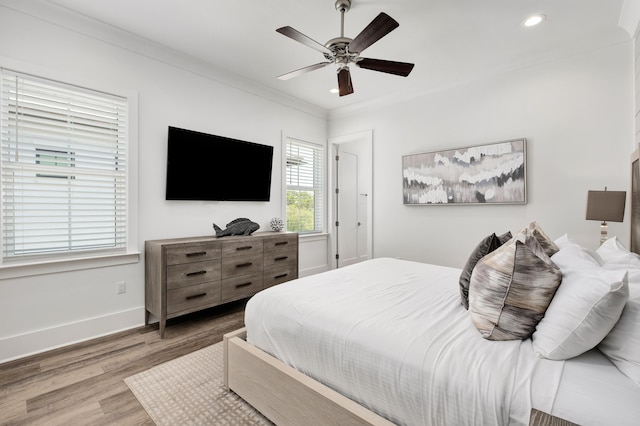 bedroom featuring ceiling fan, ornamental molding, and hardwood / wood-style flooring