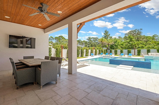 view of patio with ceiling fan and a swimming pool with hot tub