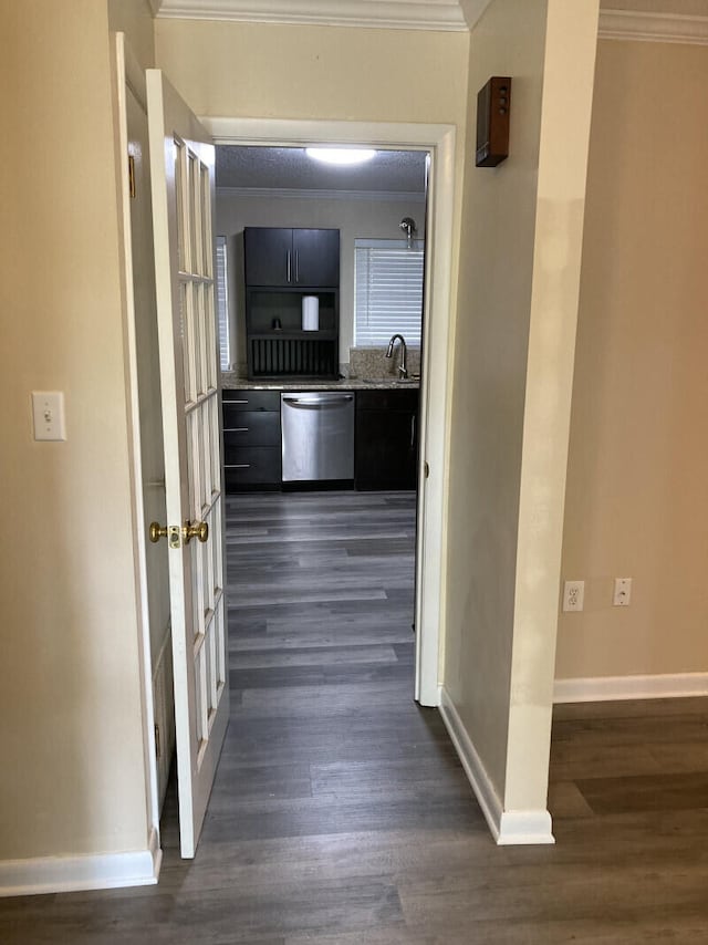 hallway with crown molding, sink, and dark wood-type flooring