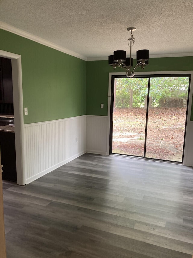 spare room with a chandelier, a textured ceiling, dark wood-type flooring, and plenty of natural light