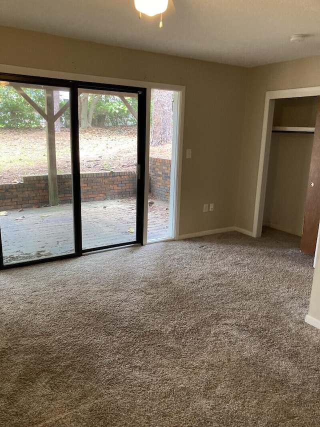 unfurnished bedroom featuring multiple windows, carpet floors, and access to outside