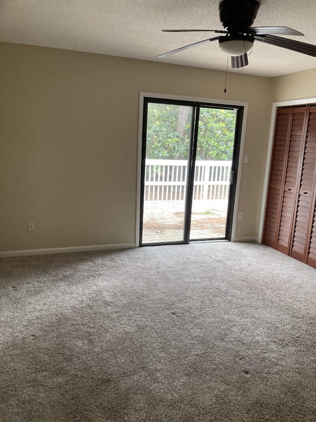 carpeted spare room featuring ceiling fan and a textured ceiling