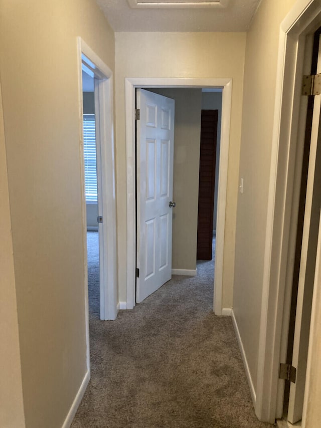 hallway featuring dark carpet