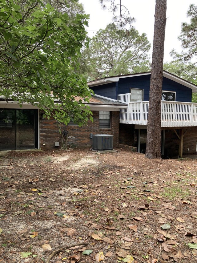 back of house featuring a wooden deck and central AC unit