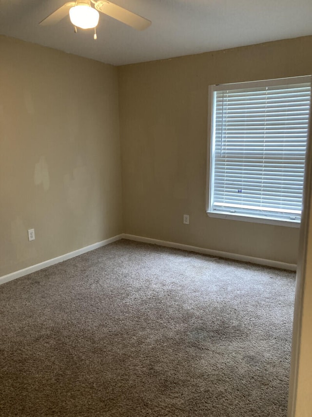 carpeted spare room featuring ceiling fan