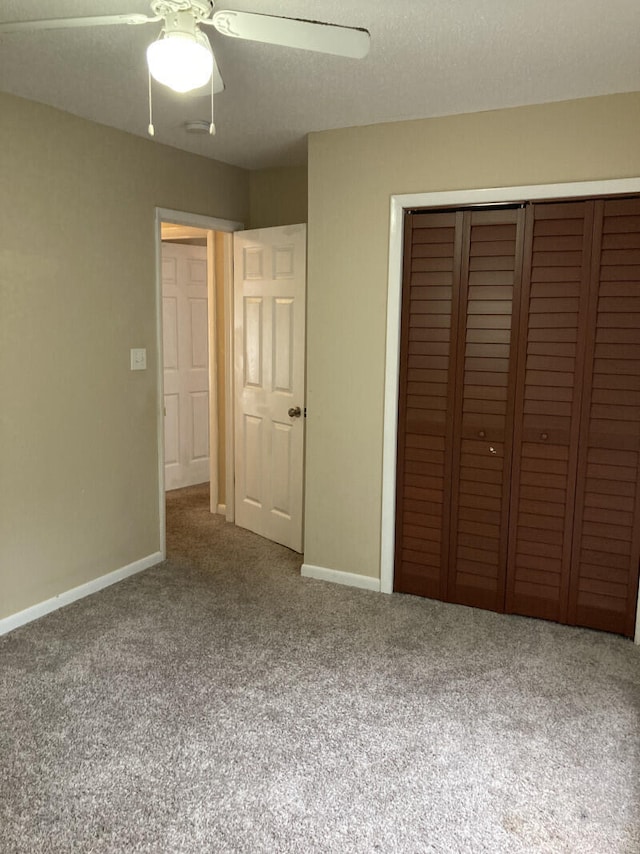 unfurnished bedroom with carpet, a closet, ceiling fan, and a textured ceiling