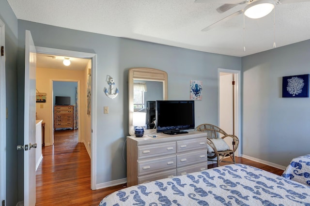 bedroom featuring ceiling fan, dark wood-type flooring, and a textured ceiling