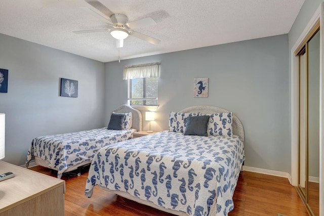 bedroom featuring hardwood / wood-style floors, ceiling fan, a textured ceiling, and a closet