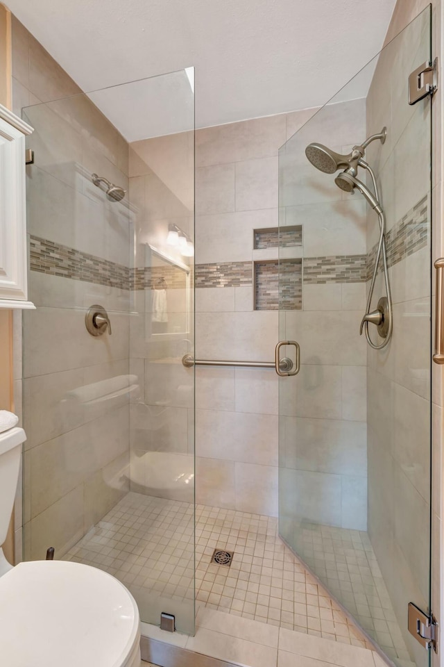 bathroom with toilet and an enclosed shower