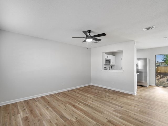 unfurnished room with ceiling fan and light wood-type flooring