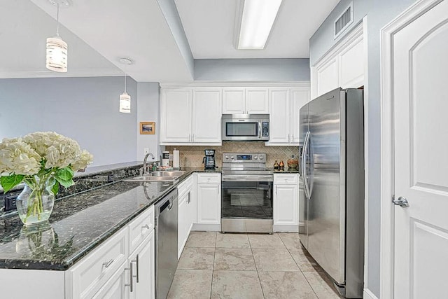 kitchen with appliances with stainless steel finishes, pendant lighting, sink, white cabinets, and dark stone counters