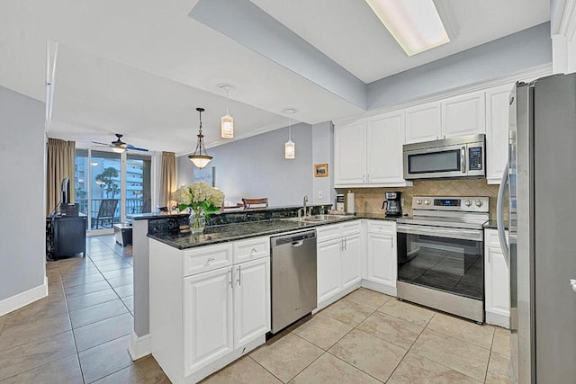 kitchen featuring sink, white cabinetry, decorative light fixtures, stainless steel appliances, and backsplash