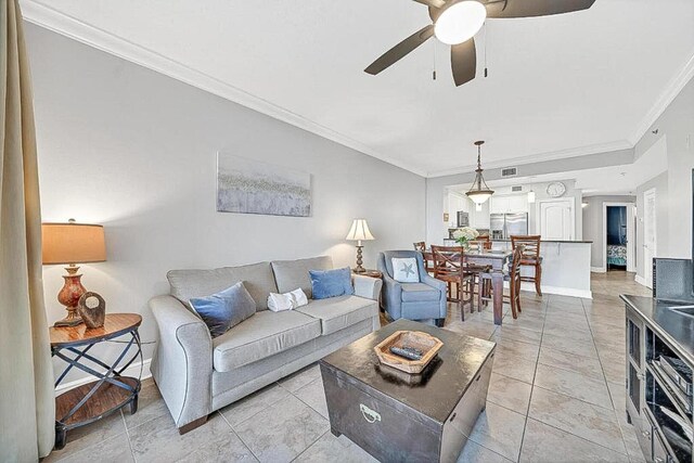 living room with light tile patterned flooring, ceiling fan, and ornamental molding