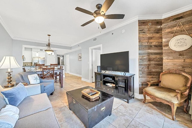 living room featuring crown molding, ceiling fan, light tile patterned flooring, and wood walls