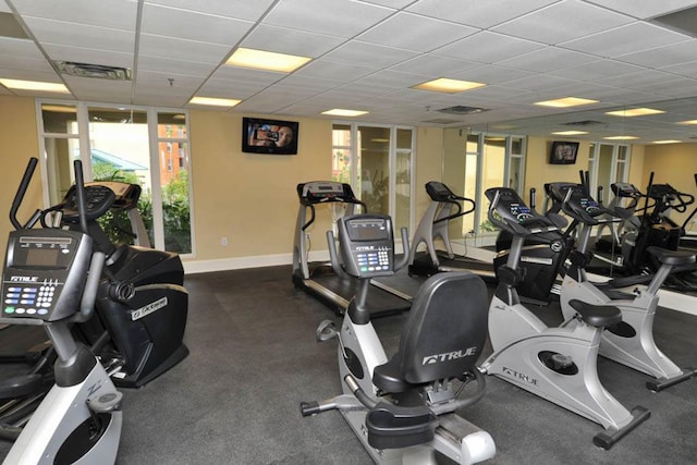 exercise room with expansive windows and a paneled ceiling