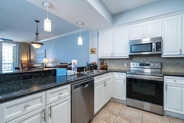 kitchen with pendant lighting, sink, stainless steel appliances, tasteful backsplash, and white cabinets