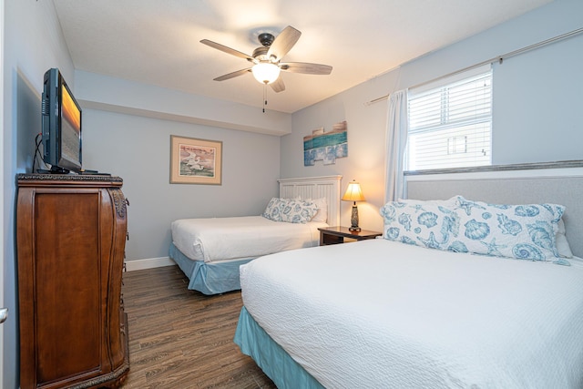 bedroom with dark hardwood / wood-style flooring and ceiling fan