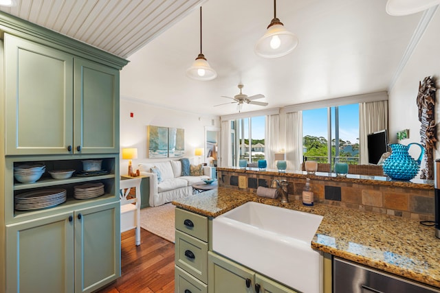 kitchen featuring ceiling fan, green cabinetry, crown molding, dark wood-type flooring, and sink