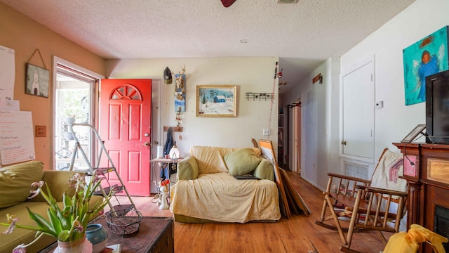 living room featuring a textured ceiling and hardwood / wood-style floors